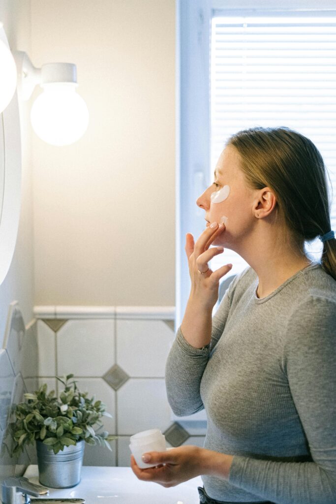 female applying sunscreen as part of morning skincare routine